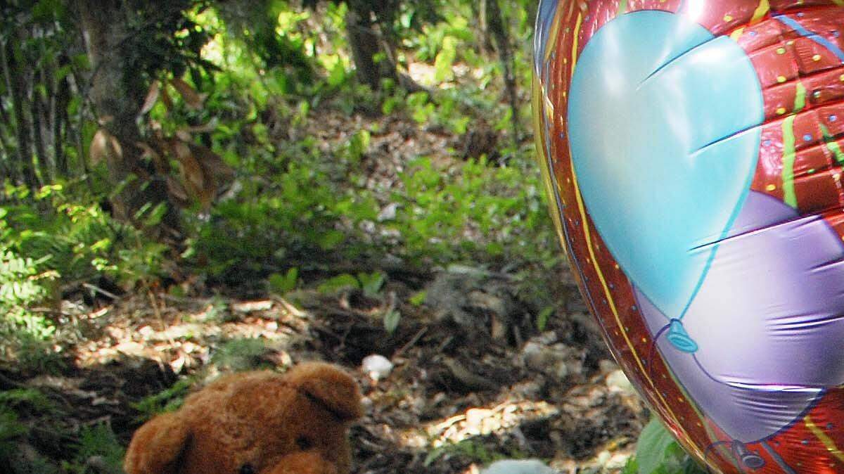Tiffany Miller, of Sanford, Fla., leaves stuffed animals and candles at a makeshift memorial on Suburban Drive where the remains of Caylee Anthony were found in Orlando, Fla.