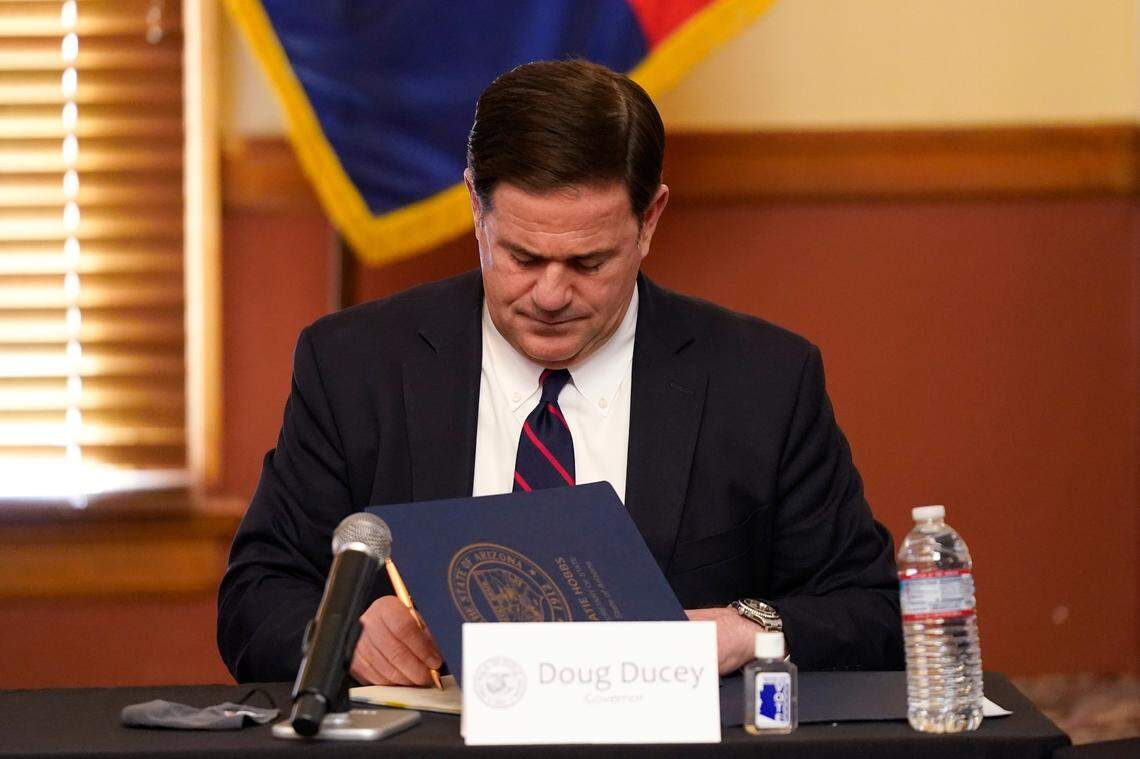 Arizona Gov. Doug Ducey signs election documents to certify the election results for federal, statewide, and legislative offices and statewide ballot measures at the official canvass at the Arizona Capitol, Monday, Nov. 30, 2020, in Phoenix. (AP Photo/Ross D. Franklin, Pool)