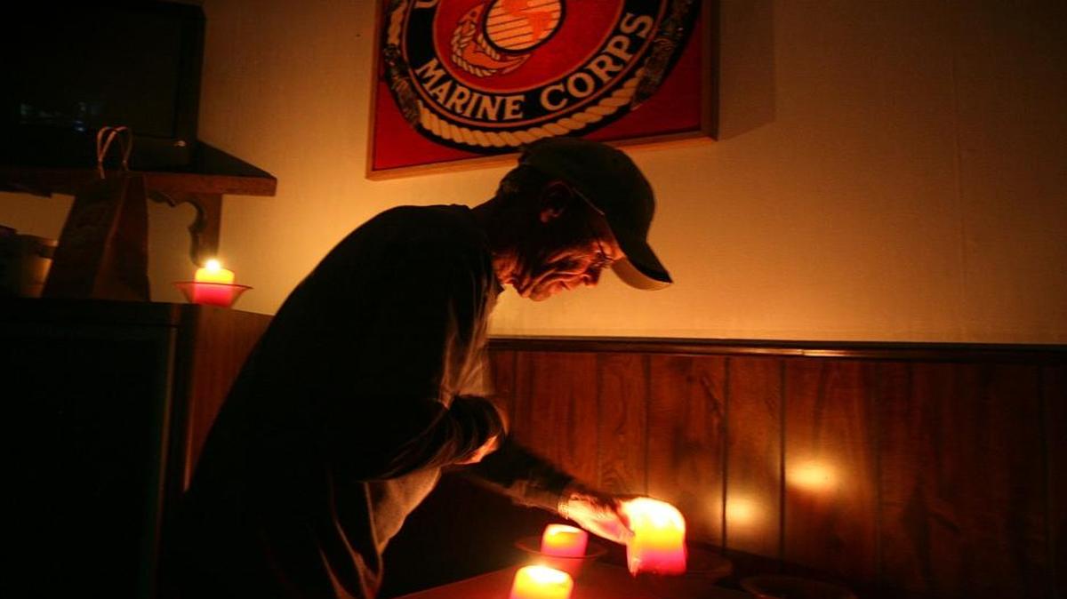 Sam Frost, a quartermaster for the VFW Post 9650 in Anderson, California, lighted candles in a March 27, 2008, vigil for Joshua Munns, a security contractor kidnapped and killed in Iraq.