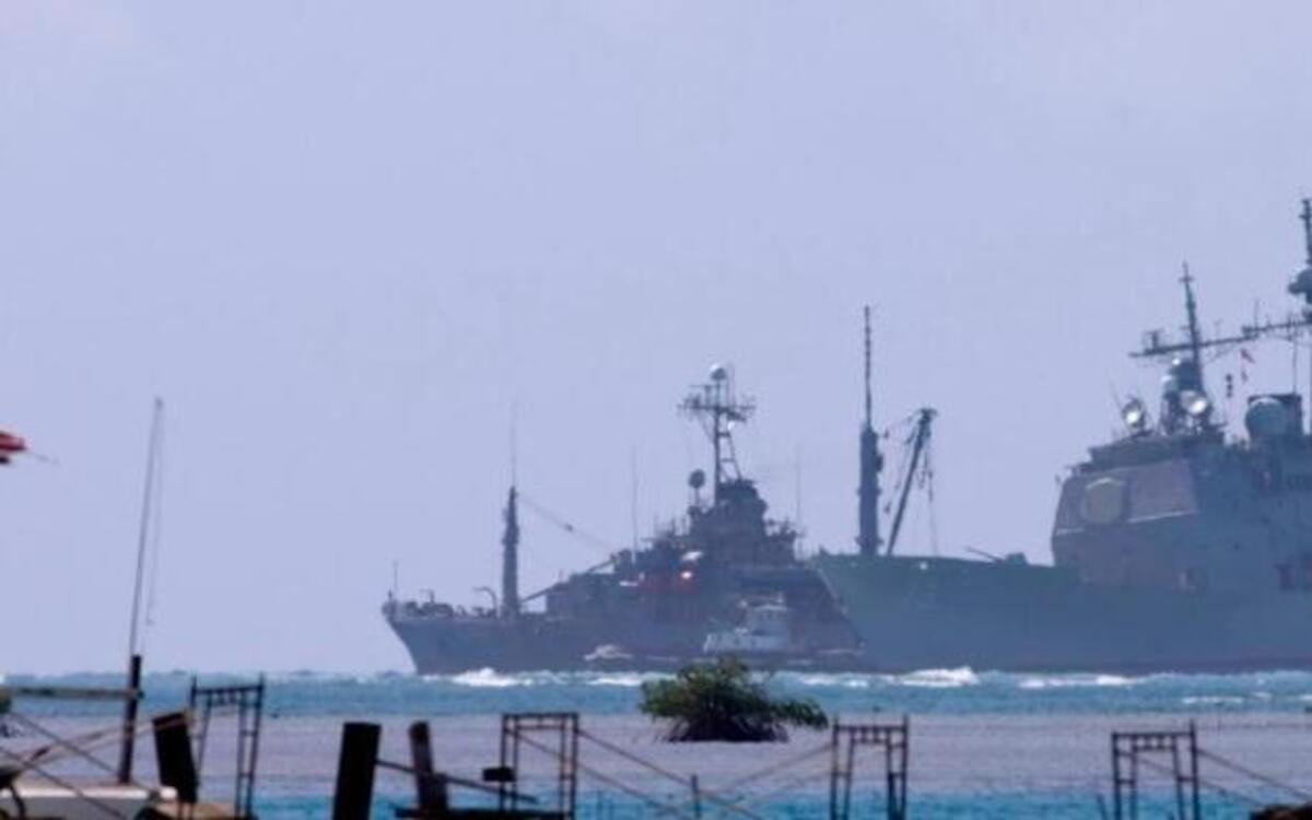 The USS Port Royal, right, a Navy guided missile cruiser, sits grounded atop a reef about a half-mile south of the Honolulu airport's reef runway, Friday, Feb. 6, 2009 in Honolulu.