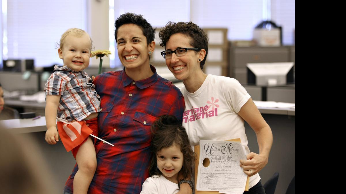 
Sanaz Faith, left, and Marta Bier pose for photos with their children after receiving their marriage license at the Travis County Clerk's office, Friday, June 26, 2015, in Austin, Texas, after the Supreme Court declared that same-sex couples have a right to marry anywhere in the United States. Texas was one of 14 states enforcing a ban on same-sex marriage. 
