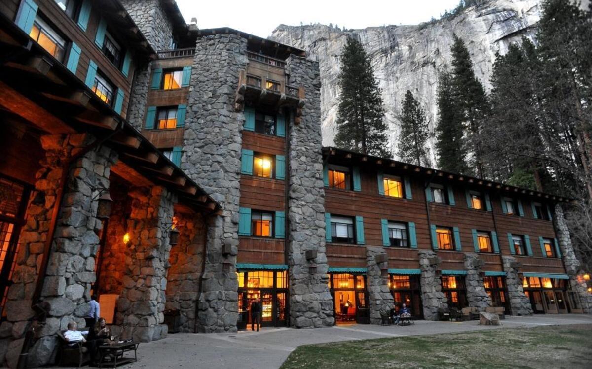 The historic Ahwahnee Hotel lit up as dusk falls over Yosemite Valley.