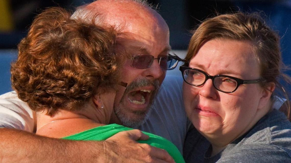 Tom Sullivan, center, embraces family members hours after losing his son Alex in the mass killings of a dozen Aurora, Colo., movie goers and the wounding of 70 others on July 20, 2012. Sullivan later told The Associated Press that, “someone else’s son having a mental problem, having easy access to weapons, all of a sudden became my problem.’’