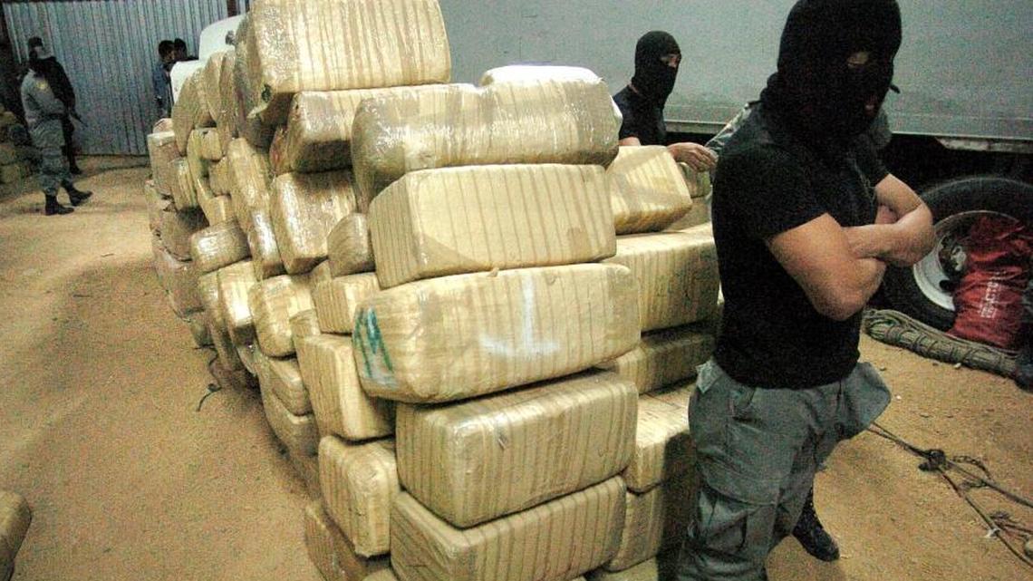 A Mexican federal police officer stands next to packages, believed to be marijuana, removed from a sophisticated clandestine tunnel which passes under the U.S.-Mexico border several years ago in Tijuana, Mexico. The amount of marijuana seized at the U.S.-Mexico border has dropped significantly since state-regulated markets have been created in some parts of the U.S.