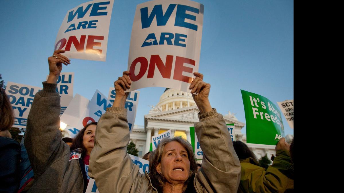 
In this photo from 2011, California teachers hold a candlelight vigil in front of the state Capitol in Sacramento, Calif. to express sympathy with union members in Wisconsin. Powerful public-sector unions are facing another high-profile legal challenge that they say could wipe away millions from their bank accounts and make it tougher for them to survive. A group of California schoolteachers, backed by a conservative group, has asked the Supreme Court to rule that unions representing government workers can't collect fees from those who choose not to join. The case comes as officials in Wisconsin and other states dealing with budged deficits have worked to reduce bargaining rights for public employees. 
