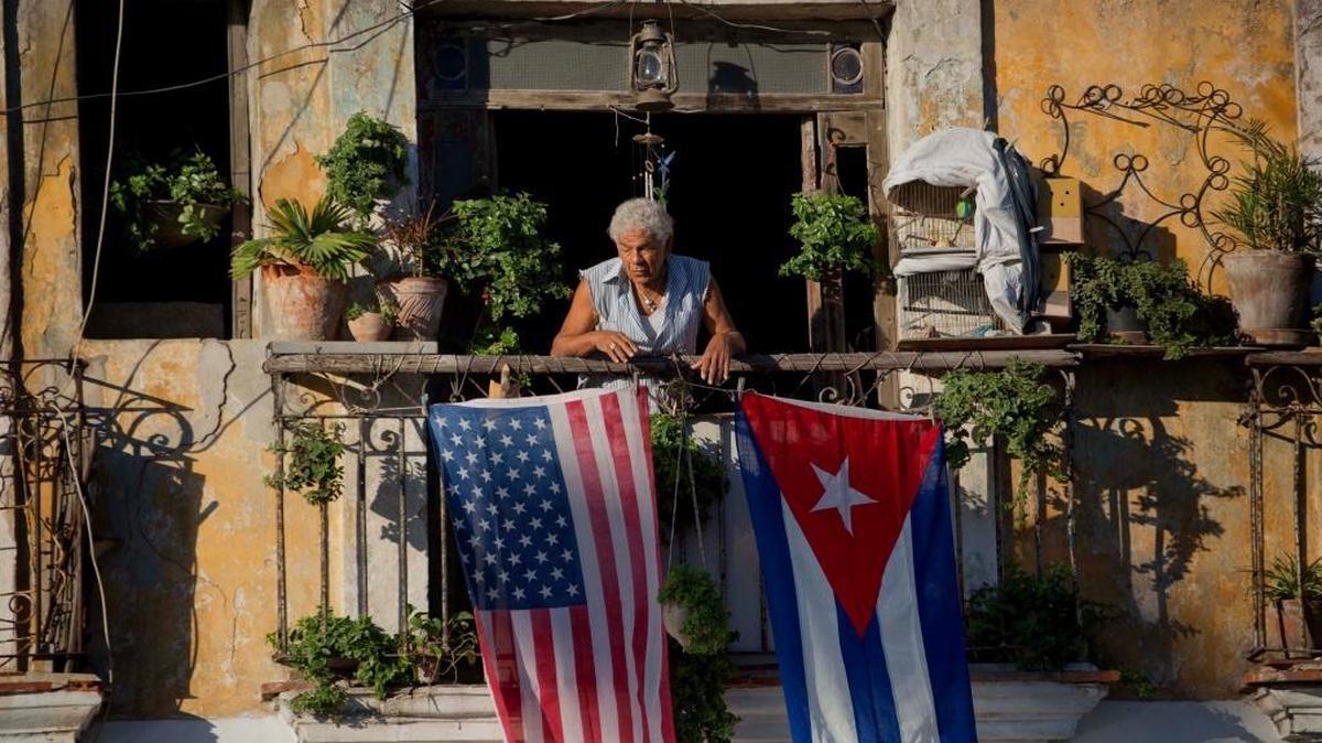 In this Dec. 19, 2014 file photo, Javier Yanez stands on his balcony decorated with U.S. and Cuban flags in Old Havana.