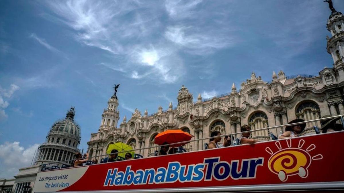 In this June 17, 2017, tourists ride a tour bus in front of the Capitolio in Havana, Cuba.