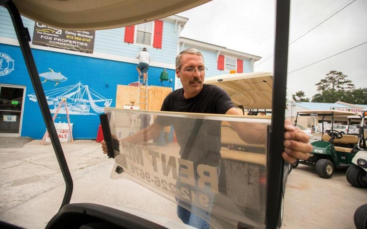 Ed Alexander, owner of Dixie Pedaled golf cart rental, removes the plastic windshield from one of his golf carts in preparation for Hurricane Matthew, Wednesday, Oct. 5, 2016, on Tybee Island, Ga.