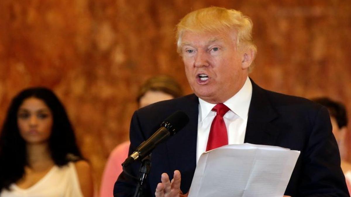 Republican presidential candidate Donald Trump reads from a list of donations to veterans groups during a news conference in New York, Tuesday, May 31, 2016.