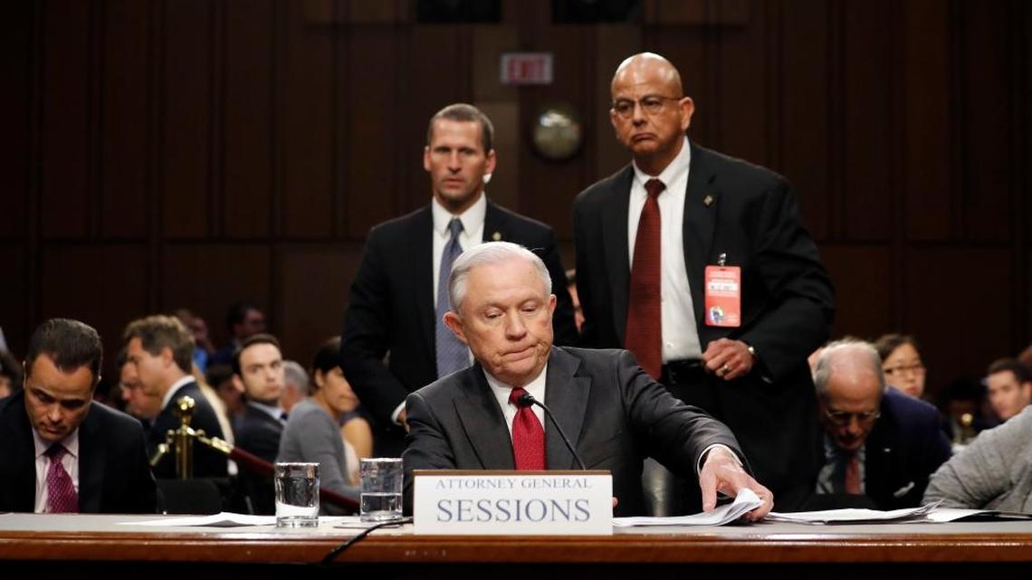 Attorney General Jeff Sessions gathers his papers as he prepares to depart on Capitol Hill.