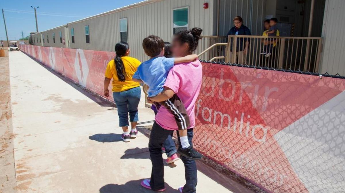 Detained mothers and children walk in common areas at a family residential center in Dilley, Texas.