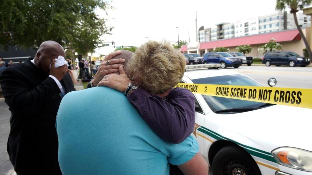 Terry DeCarlo, executive director of the LGBT Center of Central Florida, center, is comforted by Orlando City Commissioner Patty Sheehan, right, after a shooting involving multiple fatalities at a nightclub in Orlando, Fla., Sunday, June 12, 2016.