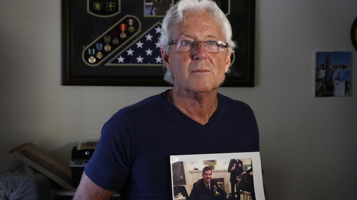 William Owens, clutching a photo of son Ryan, the SEAL killed in a January commando raid, says the administration is wrong to say that anyone who questions the raid does his son a disservice.