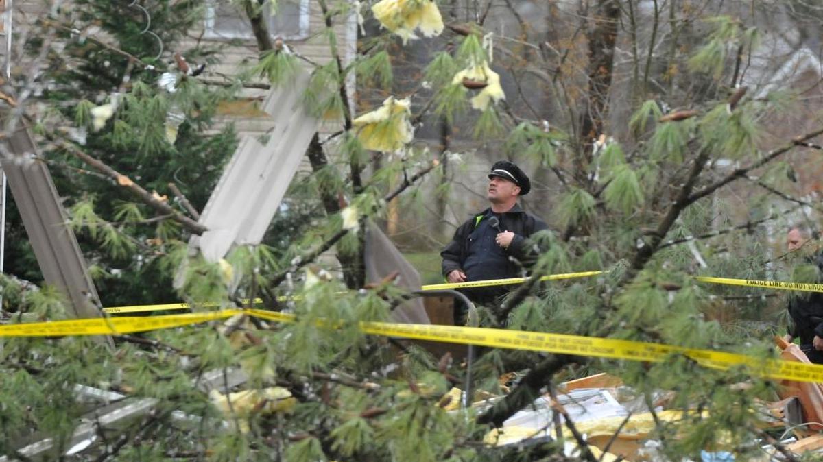 A Charlotte-Mecklenburg Police officer examines the damage in northeast Charlotte following an early morning tornado, March 3, 2012.
