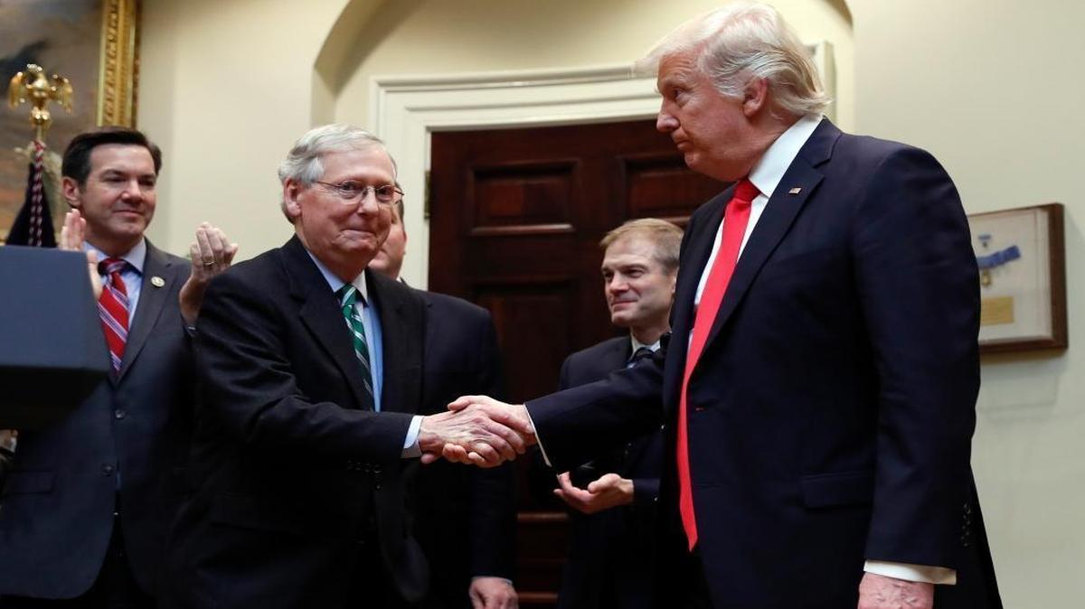 President Donald Trump shakes hands with Senate Majority Leader Mitch McConnell, R-Ky., during a ceremony where he will sign H.J. Res. 38 in the Roosevelt Room of the White House in Washington, Thursday, Feb. 16, 2017. Behind from left are Rep. Evan Jenkins, R-W.Va., and Rep. Jim Jordan, R-Ohio.