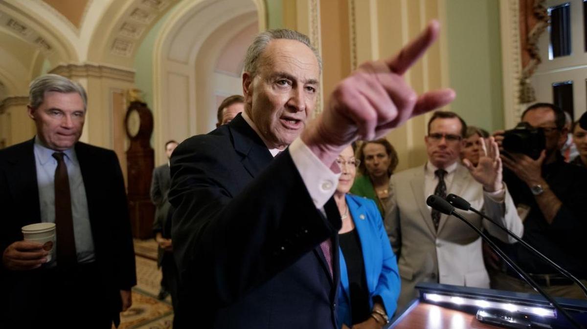 Senate Minority Leader Charles Schumer of N.Y., joined at rear by, Sen. Sheldon Whitehouse, D-R.I., and Sen. Mazie Hirono, D-Hawaii, speaks to reporters on Capitol Hill in Washington.