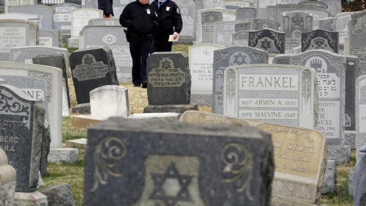 Philadelphia Police walk through Mount Carmel Cemetery, Monday, Feb. 27, 2017, in Philadelphia. More than 100 headstones have been vandalized at the Jewish cemetery in Philadelphia, damage discovered less than a week after similar vandalism in Missouri, authorities said.