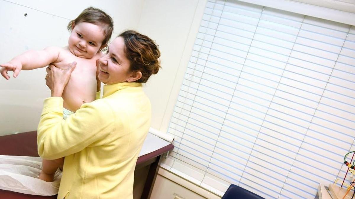 Marbell Castillo holds her granddaughter Maia Powell during the toddler's recent checkup at Burke Pediatrics in Fairfax County, Virginia. Maia is covered through the Children's Health Insurance Program.