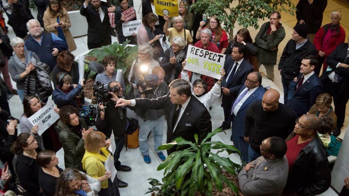 State Sen. Mike Woodard, a Durham Democrat, addresses a crowd from atop a planter in the General Assembly Building as the Republican-led legislature seeks to limit Governor-elect Roy Cooper's power during a special session Thursday, 15, 2016.
