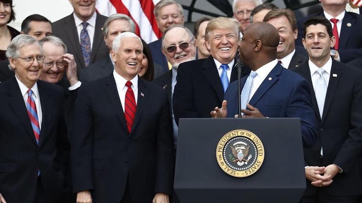 President Donald Trump smiles as Sen. Tim Scott, R-S.C., speaks during a bill passage event on the South Lawn of the White House in Washington, Wednesday, Dec. 20, 2017, to acknowledge the final passage of tax overhaul legislation by Congress.