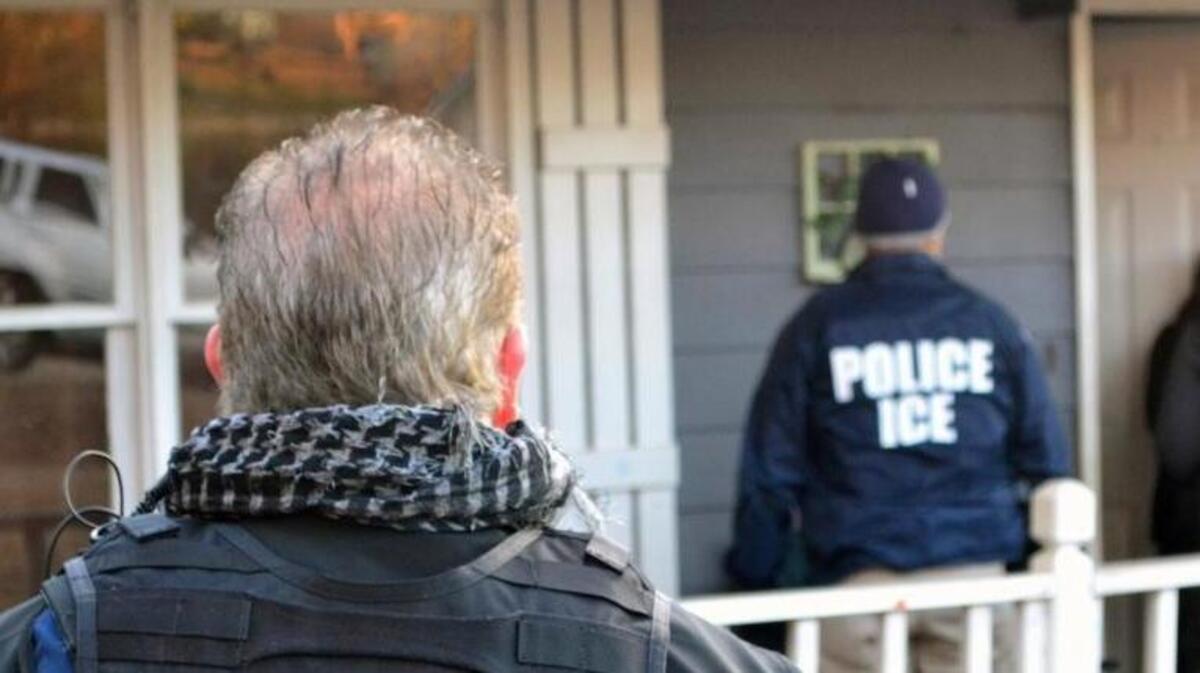 Immigration enforcement agents stand outside a home in Atlanta during a targeted enforcement operation aimed at immigration fugitives, re-entrants and at-large criminals living in the country illegally. ICE provided this photo.