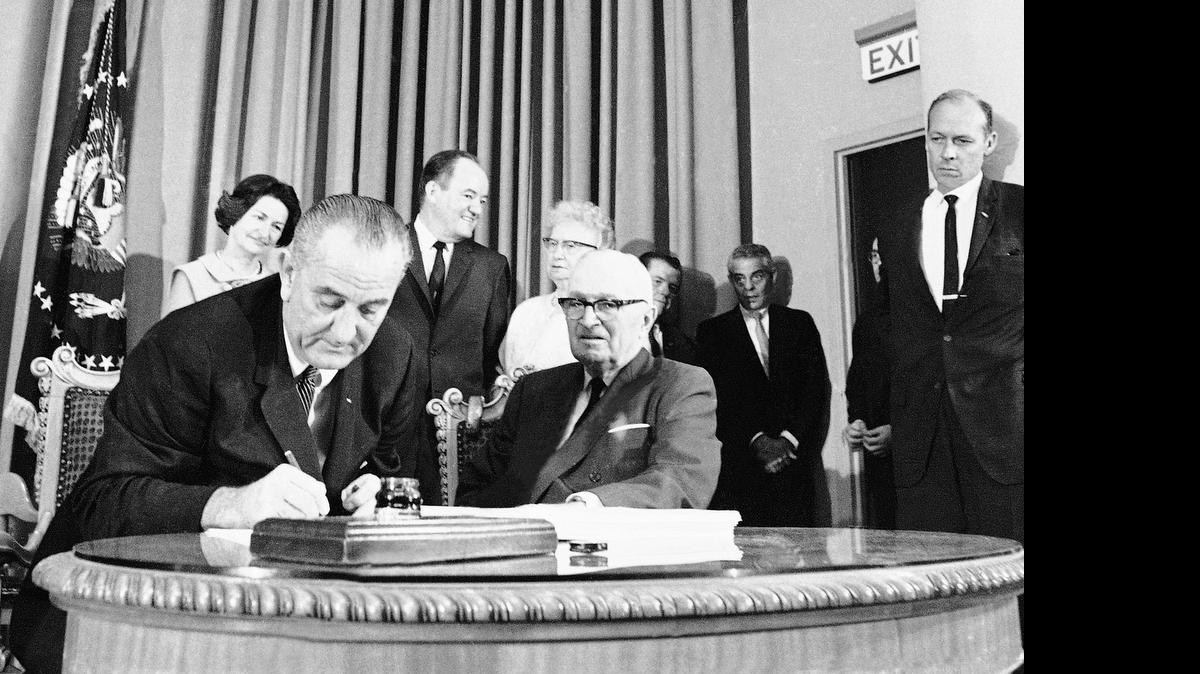 
President Lyndon B. Johnson, left, with former President Harry S. Truman at his side, signs the Medicare Bill into law at ceremonies at the Truman Library in Independence, Missouri on July 30, 1965. Medicare is for people age 65 and older and Medicaid is for the poor. His legendary arm-twisting and a Congress dominated by his fellow Democrats succeeded in creating the kind of landmark health care programs that eluded his predecessors.
