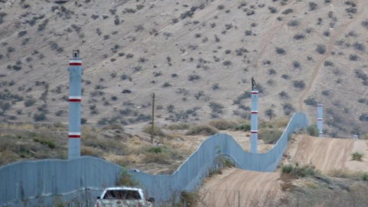 In this Jan. 4, 2016 photo, a U.S. Border Patrol agent drives near the U.S.-Mexico border fence in Sunland Park, N.M. A spike in families and children arriving at the U.S. southern border from Central America has prompted fears of another crisis like the one that dominated national news during the summer of 2014. (AP Photo/Russell Contreras)