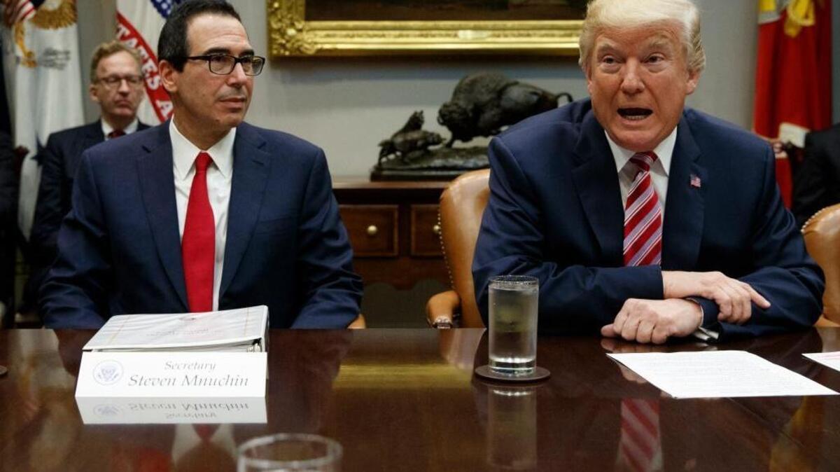 Treasury Secretary Steve Mnuchin listens as President Donald Trump speaks during a meeting on tax policy in the Roosevelt Room of the White House this week. Close former business partners of Mnuchin are now facing allegations of sexual misconduct in a widening Hollywood scandal.