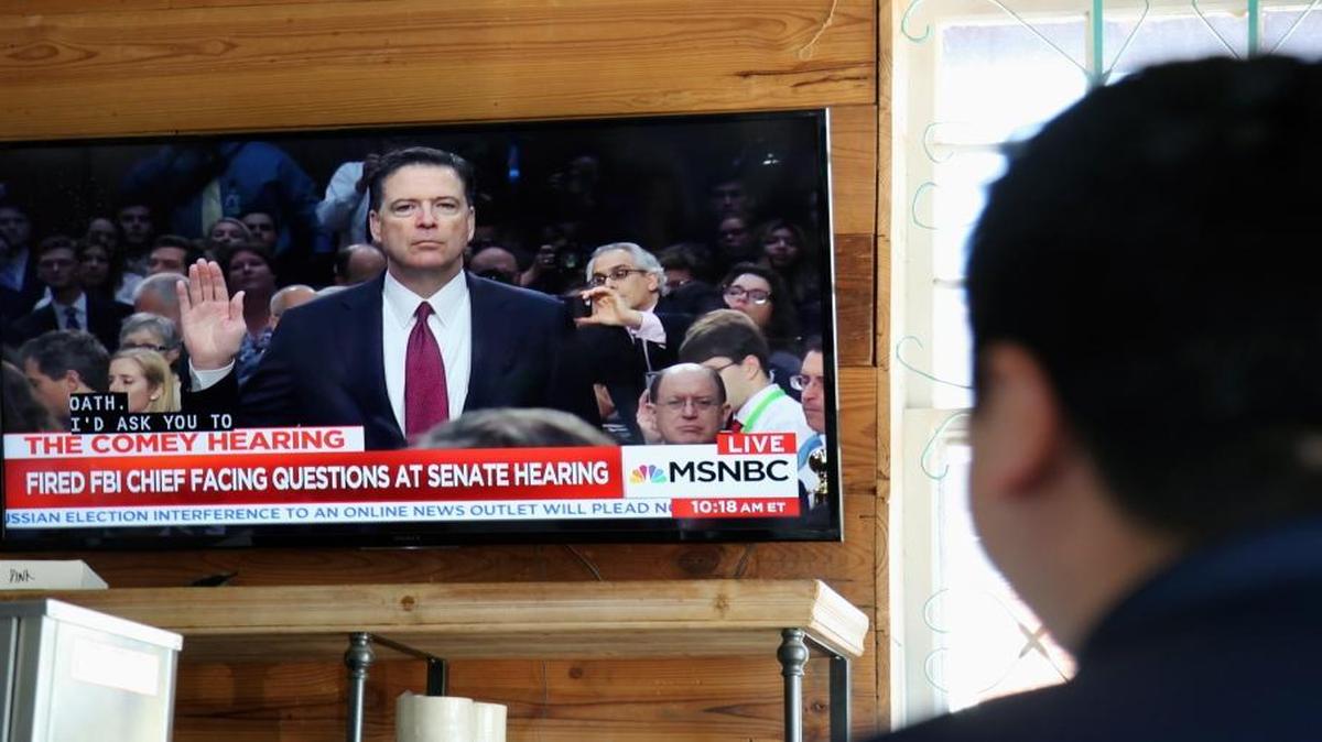 A patron at the Axelrad bar in Houston watches a television as former FBI director James Comey is sworn in before he testified at a U.S. Senate Intelligence Committee hearing on June 8 2017.