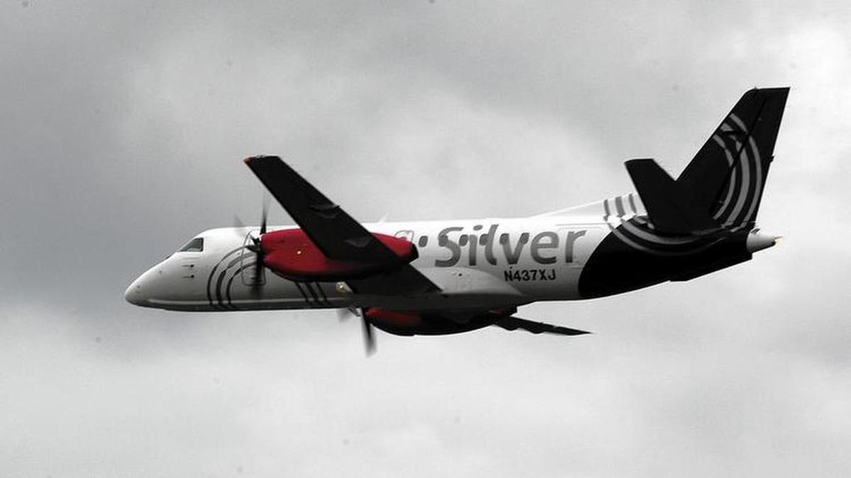 A Silver Airways aircraft flies over the company's Fort Lauderdale hangar.