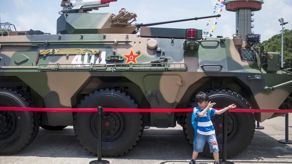 
A child pretends to hold a gun while posing for a photograph in front of a People's Liberation Army tank in Hong Kong in July.
