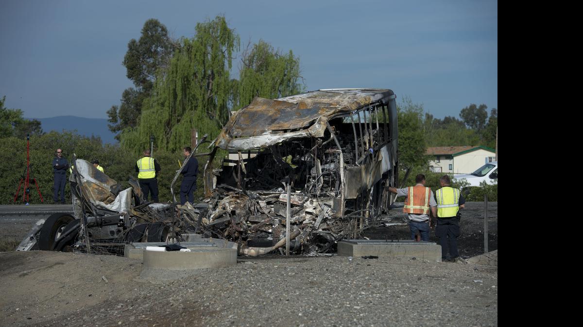 
Workers begin clearing the charred remains of a charter bus that collided with a FedEx tractor trailer on Interstate 5 in Orland, Calif., on April 10, 2014. Ten people were killed in the crash and dozens more were injured.
