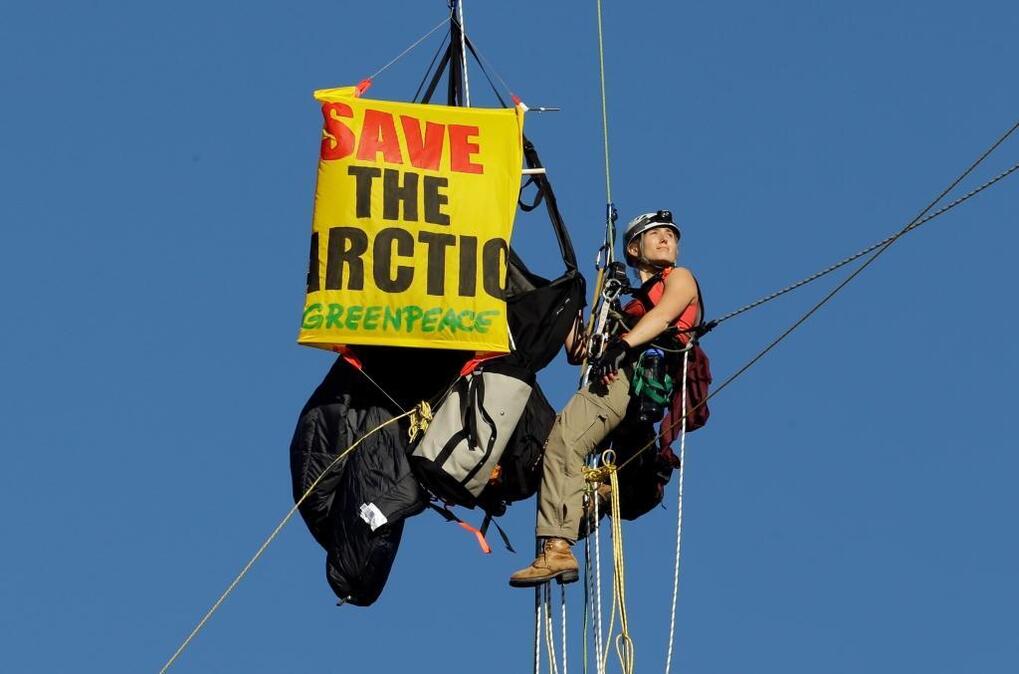 
An activist looks towards the rising sun as she hangs from the St. Johns bridge as part of a protest to block the Royal Dutch Shell PLC icebreaker Fennica from leaving for Alaska in Portland, Ore., Thursday, July 30, 2015. The icebreaker, which is a vital part of Shell's exploration and spill-response plan off Alaska's northwest coast, stopped short of the hanging blockade, turned around and sailed back to a dock at the Port of Portland. On Monday, Aug. 17, 2015, the Interior Department said it would let Shell drill deep enough off Alaska’s northwest coast to find oil. (AP Photo/Don Ryan)
