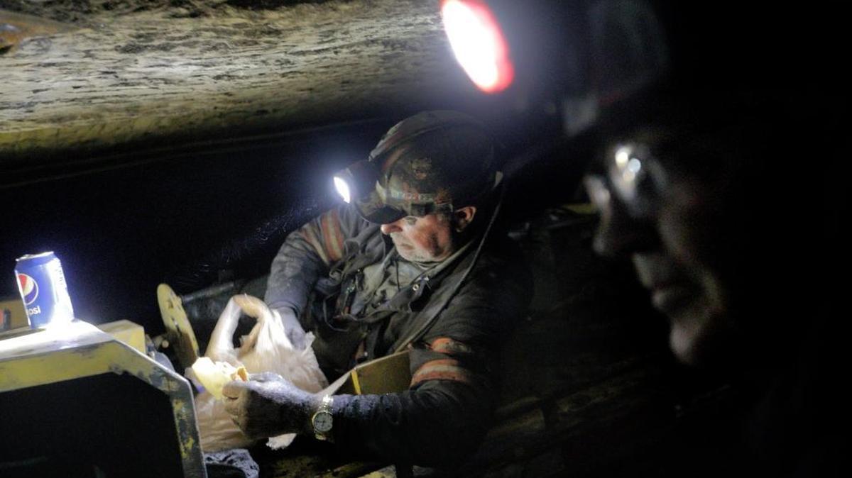 Scott Tiller, a coal miner of 32 years, eats his lunch while laying down on a man trip, a cart that shuttles miners underground, as he works a shift in a mine less than 40-inches high in Welch, W.Va., on May 11, 2016.