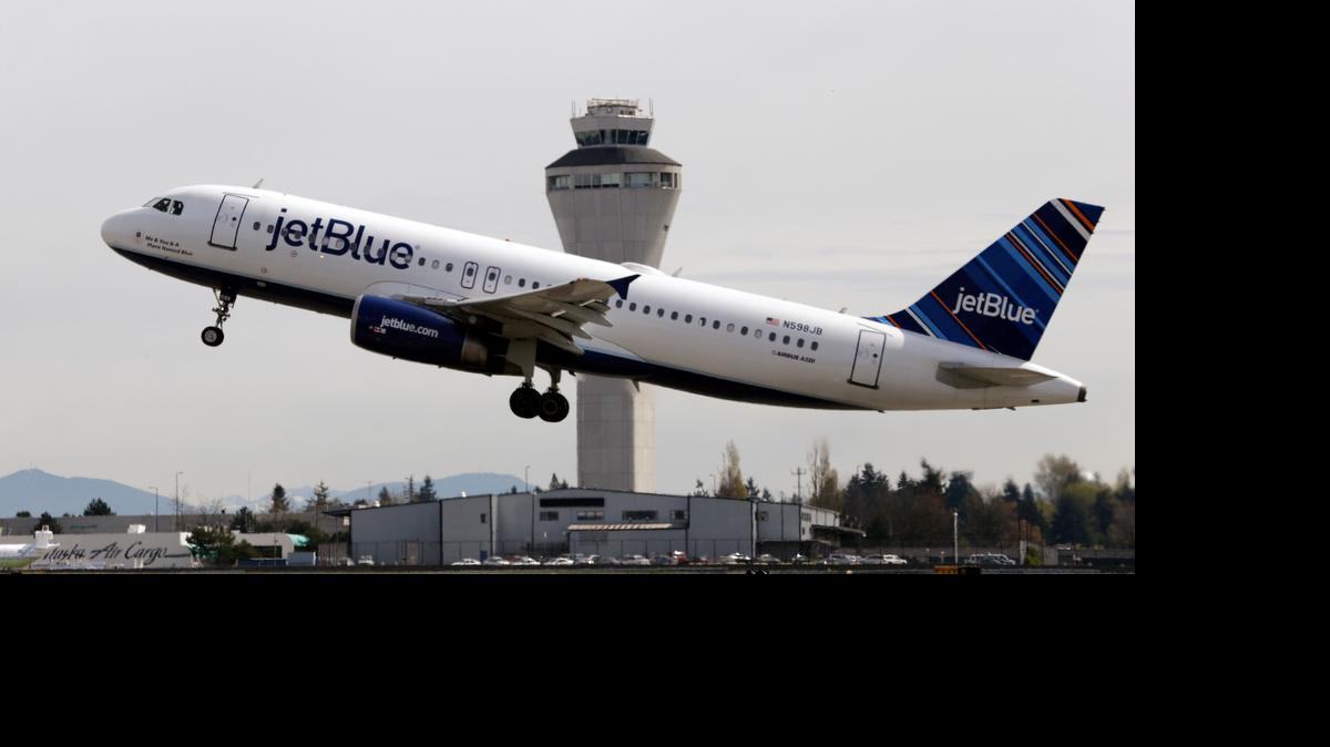 
In this April 23, 2013, file photo, a JetBlue plane takes off in view of the air traffic control tower at Seattle-Tacoma International Airport, in Seattle. JetBlue, which has proudly proclaimed itself a holdout on fees for years, on Tuesday, June 30, 2015, said it will now charge up to $25 for checked luggage, although many passengers will pay less by planning ahead.
