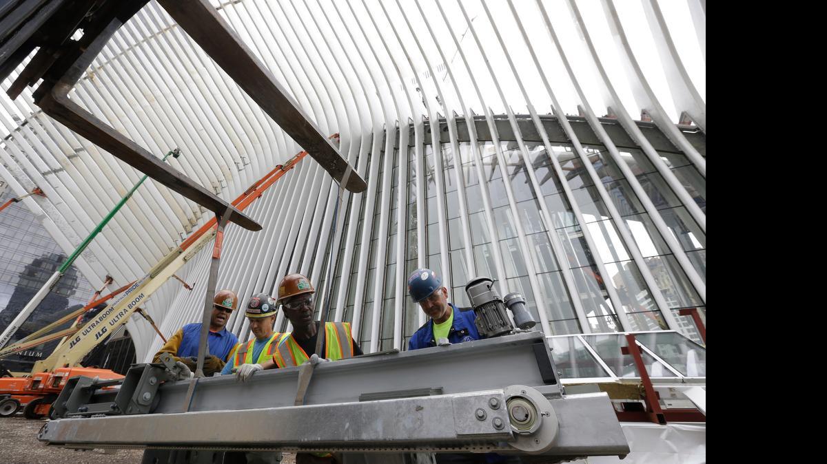 
 In this June 18, 2015, file photo, construction workers secure a steel apparatus to a crane that will be used on the roof of the Oculus structure at the World Trade Center transportation hub, in New York.

