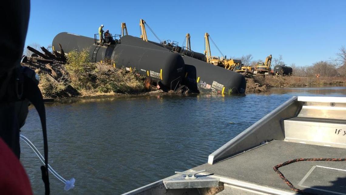 Workers inspect railroad tank cars damaged in a derailment near Alma, Wis., on Nov. 8, 2015.