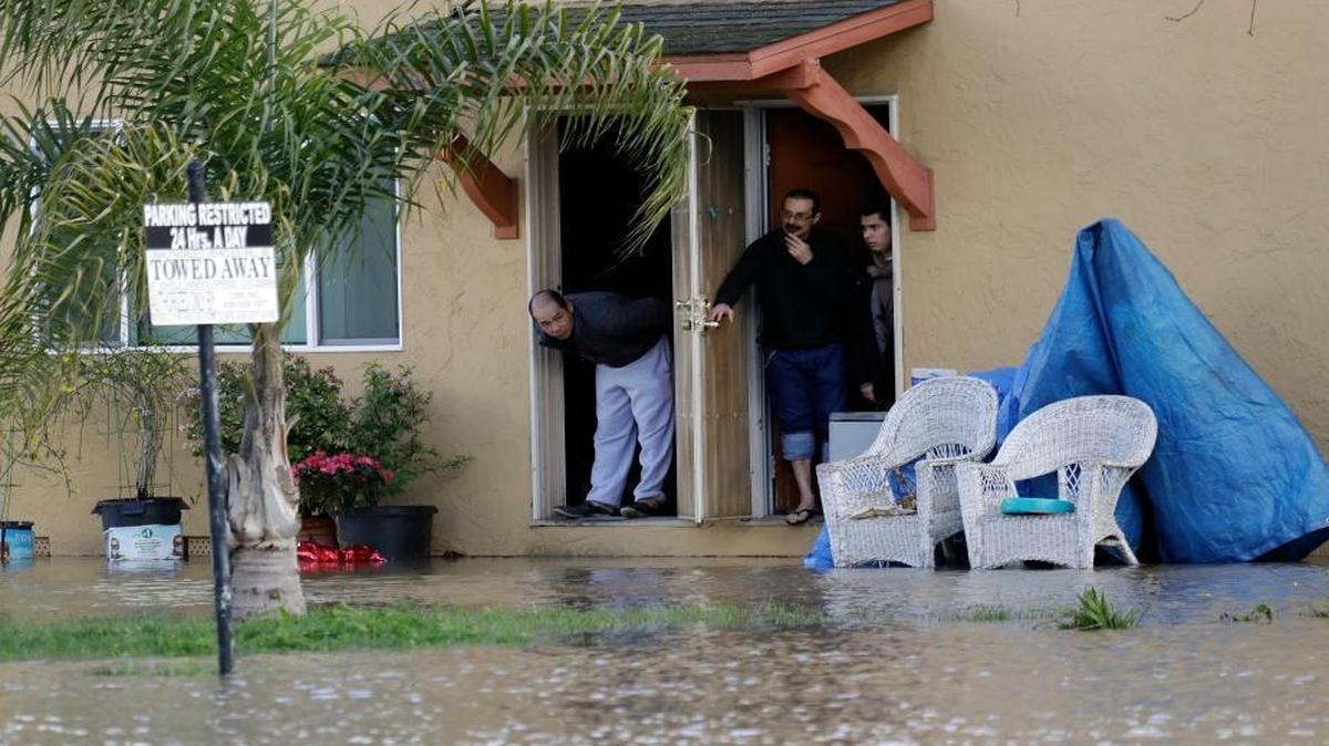 People look out from the front door of a flooded apartment complex in San Jose, Calif. Rains have saturated once-drought-stricken California but have created chaos for residents. The latest downpours swelled waterways to flood levels and left about half the state under flood, wind and snow advisories.
