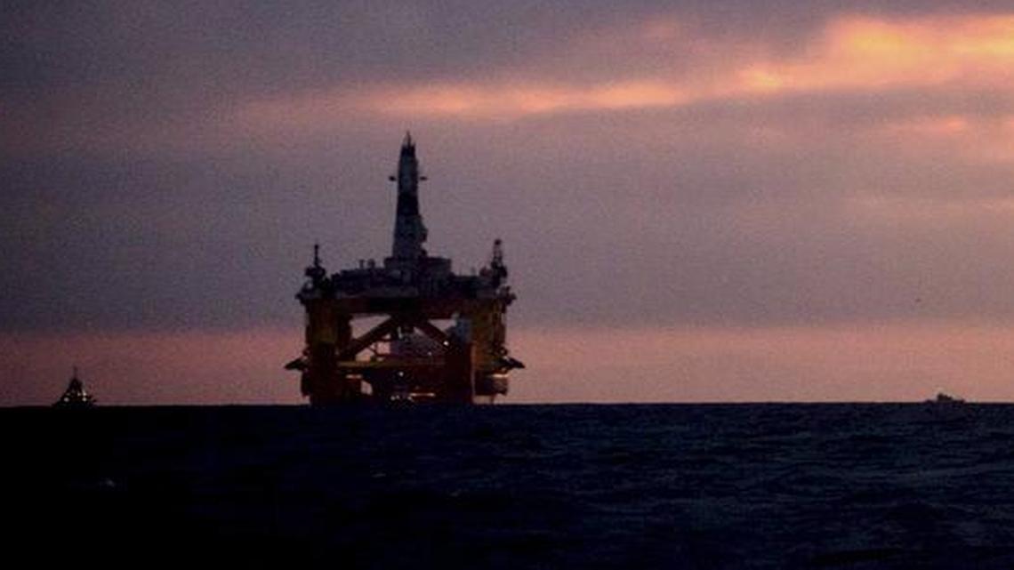 An oil drilling rig arrives aboard a transport ship at sunrise, following a journey across the Pacific in Port Angeles, Wash. on April 17, 2015. Royal Dutch Shell hopes to use the rig for exploratory drilling during the summer open-water season in the Chukchi Sea off Alaska's northwest coast.