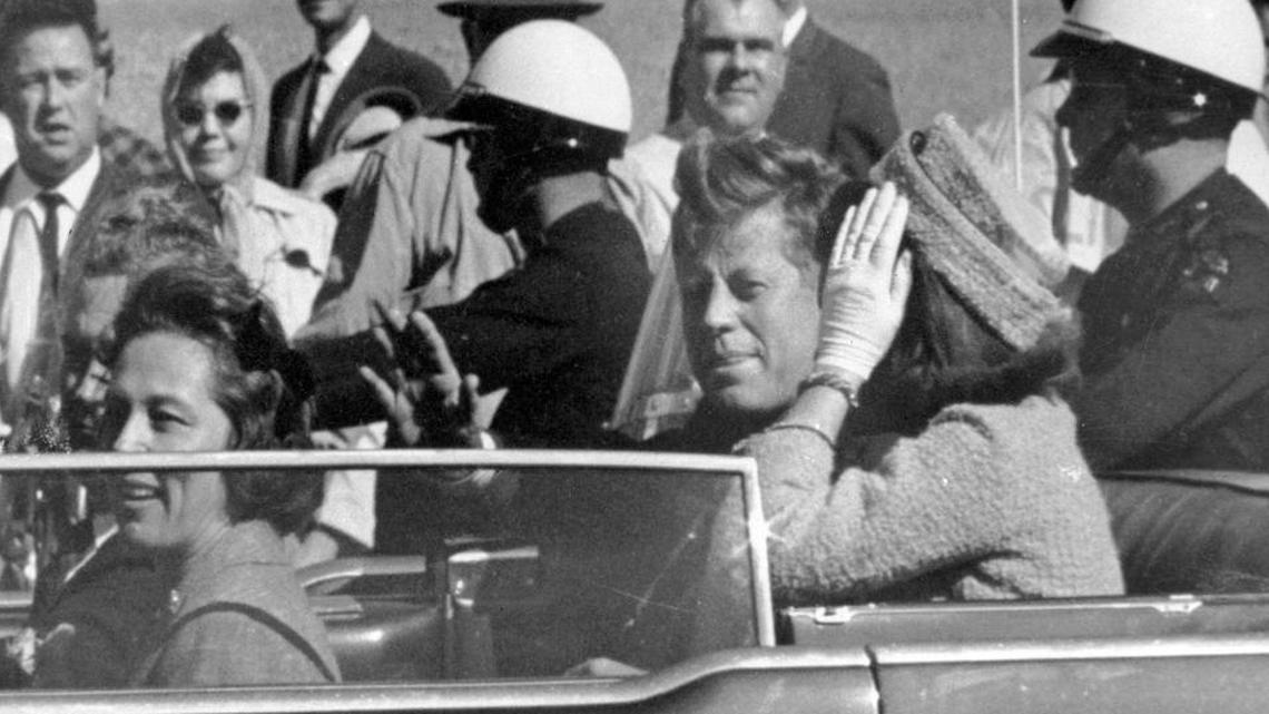 In this Nov. 22, 1963 file photo, President John F. Kennedy waves from his car in a motorcade in Dallas. Riding with Kennedy are First Lady Jacqueline Kennedy, right, Nellie Connally, second from left, and her husband, Texas Gov. John Connally, far left. (AP Photo/Jim Altgens, File)