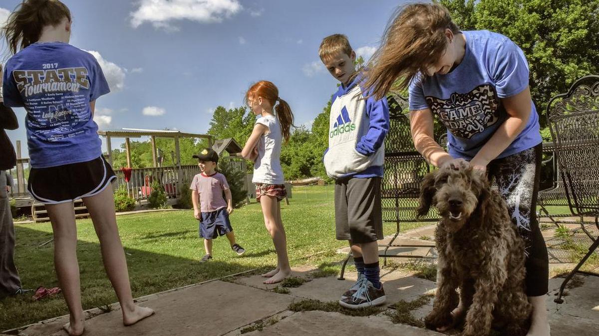 Kristie Bradley of Newcastle, Oklahoma, with Bandit, the family dog, spends time with her children, from left, Leah, 11, Cooper, 3, Macy, 7, and Colton, 9, on a Friday, now that they no longer have school that day because of budget cuts.