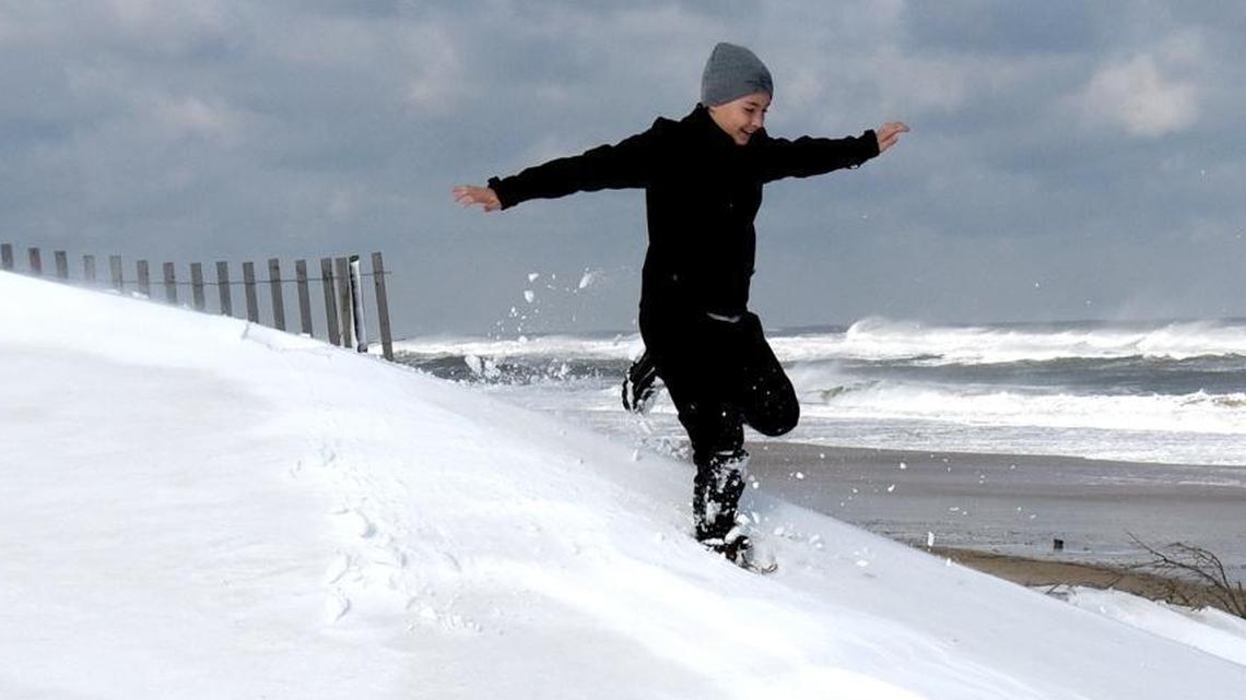 Nathan Stanley, 12 , of Abington, Va. runs through a beachfront snowdrift on Jan. 4, 2018 in Nags Head, North Carolina. Despite warming temperatures in much of the world, winters in the Southeast have grown colder in recent decades, an anamoly that scientists are calling a “hole” in global warming, or a “warming hole.”