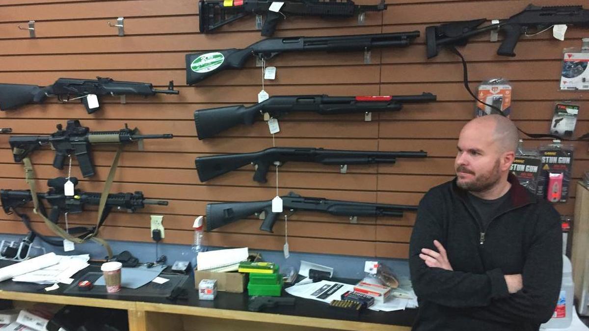 Firearms salesman Nathan Williams, 37, of Albuquerque, attends to customers at The Outdoorsman gun shop in Santa Fe, N.M.