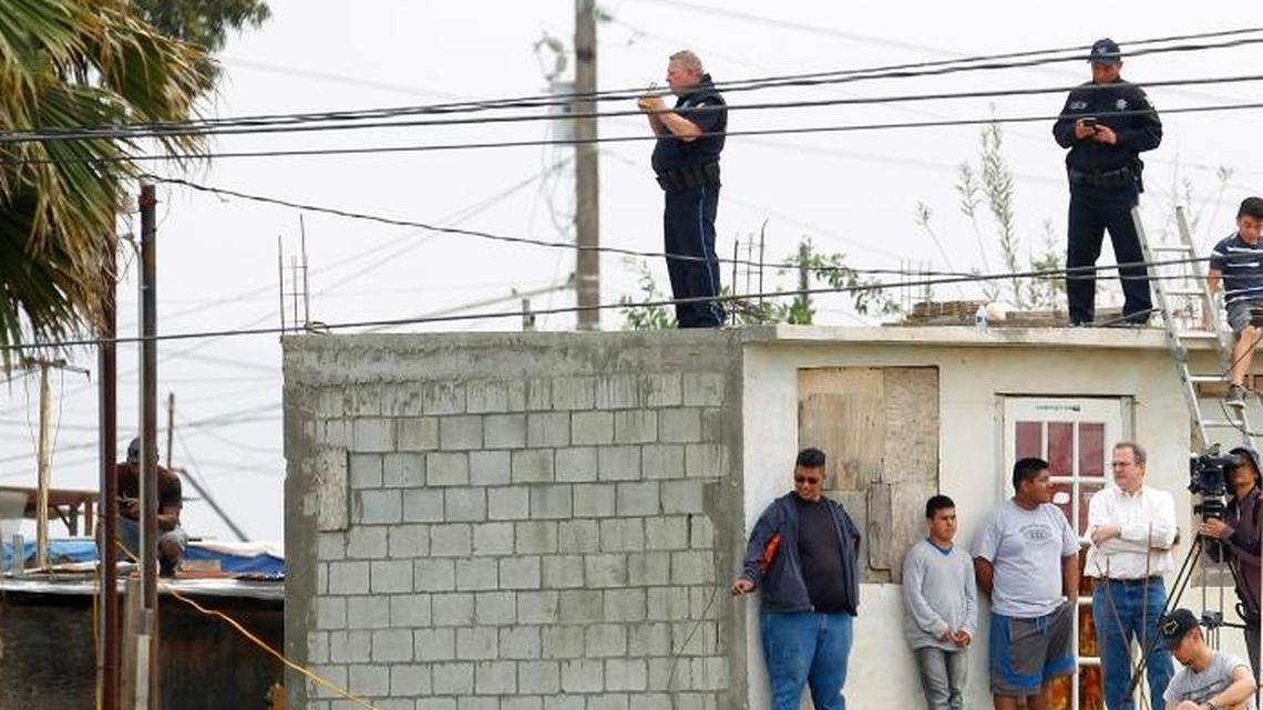 People in Mexico watch as President Donald Trump tours the border wall prototypes near the Otay Mesa Port of Entry in San Diego County, Calif., last month.