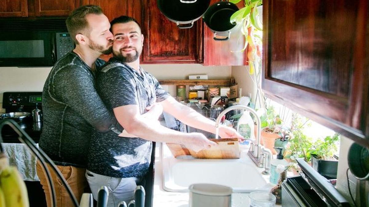 Shadi Ismail, right, gets a kiss from boyfriend Ian Guthrie while washing dishes in their home in Boise, Idaho, on Friday, Sept. 9, 2016. Ismail, a Syrian refugee, says about his new life in Boise: “I didn't think I would be alive” to experience life in the U.S. “I wish everyone had what we have.” Despite resistance by Idaho’s top political leaders, 118 Syrian refugees have moved to the Gem State since last Oct. 1, all of them settling in Boise, according to new data from the State Department.