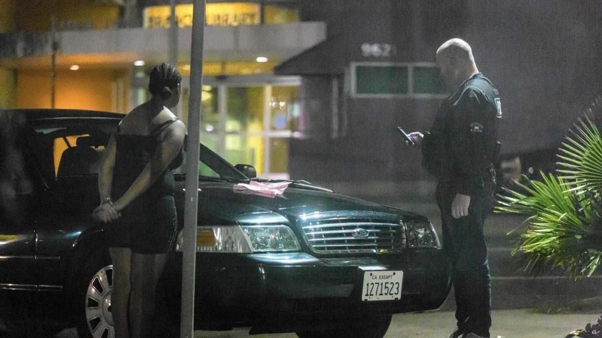A police officer questions a girl in a South Los Angeles area known for sex trafficking involving minors.