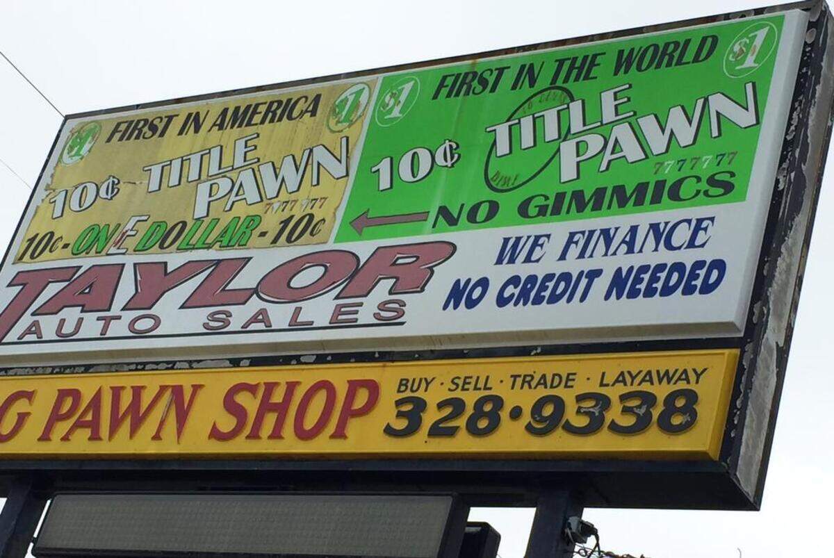 This title-pawn shop in Warner Robins, Ga., shares a parking lot with, and is adjacent to, a used car dealership. Title-pawn companies sometimes set up next to dealerships and repair shops where customers need quick cash.
