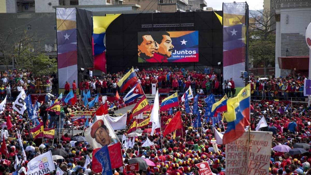Supporters gather at Diego Ibarra square to listen Venezuela's President Nicolas Maduro speak after a ceremony formalizing Maduro's candidacy as a candidate for the upcoming presidential election, in Caracas, Venezuela, Tuesday, Feb. 27, 2018.