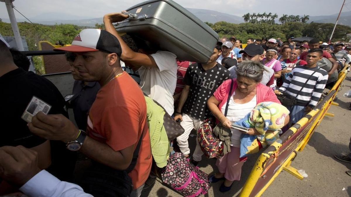 In this Feb. 21, 2018 photo, Venezuelans cross the International Simon Bolivar bridge into the Colombia. As Venezuela's economic crisis worsens, rising numbers are fleeing in a burgeoning refugee crisis that could soon match the flight of Syrians from the war-torn Middle East.