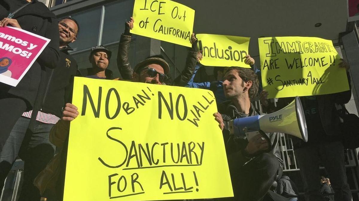 Protesters hold up signs opposing President Trump’s policy on sanctuary cities last year in San Francisco.